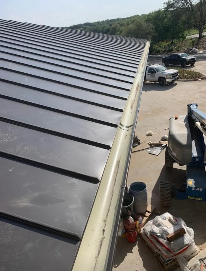 Standing seam panel and gutter detail on a metal roofing jobsite in Bagley